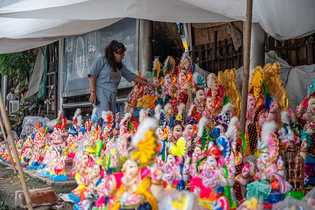 A customer selects Ganesh idols displayed for sale at a roadside market near Jhandewalan ahead of the Ganesh Chaturthi festival. Ganesh Chaturthi, one of the most cherished festivals, celebrates the birth of Lord Ganesha, the god of wisdom and prosperity. Observed with grandeur especially in Maharashtra and southern states, devotees install clay idols in homes and pandals, offer prayers and relish modak.
