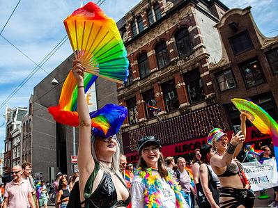 A person is seen holding a rainbow fan in the air while walking. The annual equal rights demonstration for the global rainbow community took place in Amsterdam. Thousands of people and organisations walked from Dam square, crossing the city center, and ending at the Vondelpark. Under the motto 'Be who you are, love who you want', Pride Amsterdam wants the acceptance and equality of LGBTI people around the world.