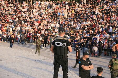 A Palestinian policeman stands on guard while fans watch the World Cup match between Egypt and Argentina. Palestinian fans seen at Jamal Abdel Nasser Stadium, watching the match via live World Cup broadcast big screen tv. Final scores; Argentina 3 : 2 Egypt.