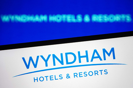 In this photo illustration a Wyndham Hotels & Resorts logo is seen on a smartphone screen.