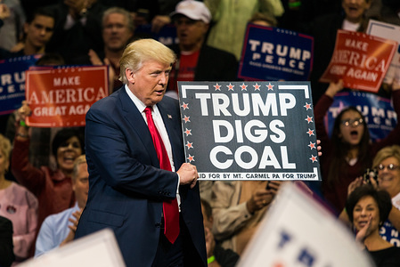 Donald Trump holding "Trump Digs Coal" sign while campaigning for president at the Mohegan Sun Arena in Wilkes-Barre.