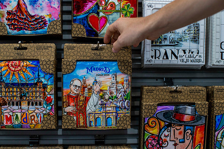 A man picks up a tile depicting Pope Leo XIV during his visit to Spain, an unofficial souvenir, in a shop in central Madrid. Pope Leo XIV will visit Spain from June 6 to 12, 2026, touring Madrid, Barcelona, Gran Canaria, and Tenerife.