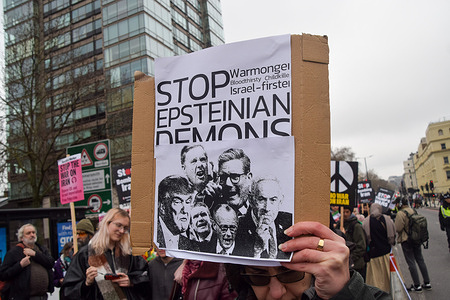 A protester holds a placard referencing Jeffrey Epstein during the demonstration in Millbank. Thousands of people marched to the Embassy of USA in protest against the US and Israel's war on Iran.