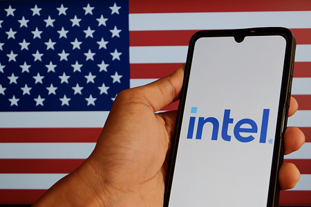 In this photo illustration, the Intel logo seen displayed on a smartphone and the American flag in the background.
