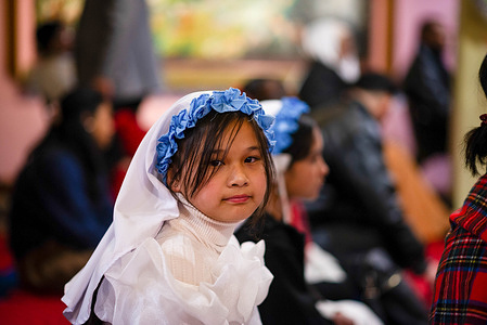 A little girl attends the Christmas Eve gathering in a church to celebrate Christmas. Christmas is an annual festival commemorating the birth of Jesus Christ, observed as a religious and cultural celebration among people around the world.