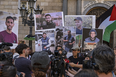 A media spokesperson speaks at a press conference with people holding portraits of the Al Jazeera journalists recently killed in Gaza by the Israeli army. Hundreds of journalists from information and media entities gathered in Plaza de Sant Jaume to protest against the murder of journalists in Gaza perpetrated by the Israeli army to silence free information about the Palestinian genocide.
