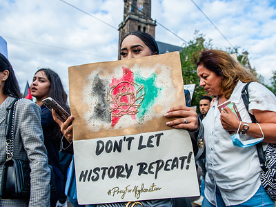 An Afghan woman holds a placard with an illustration of an Afghan flag during the demonstration.
Thousands of people gathered in the center of Amsterdam to show their support for the Afghanistan people trapped in Kabul under the Taliban regime and to urge the Dutch Government to declare Afghanistan an unsafe country of origin so Afghan refugees and Afghan undocumented people can have the legal right to asylum and safety.