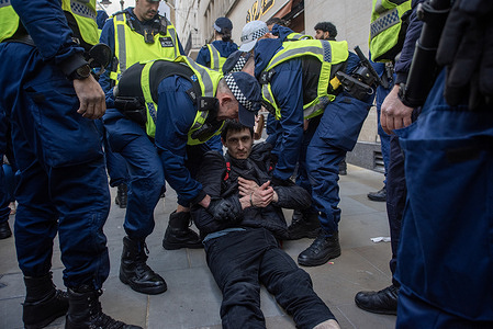 Members of the Territorial Support Group (TSG) seen arresting an animal rights activist outside Louis Vuitton fashion shop (not in view). Members of the Rage Activism targeted the Louis Vuitton fashion shop on the New Bond Street in London, UK. The Rage Activism is a vegan animal rights group fight against animal exploitation.