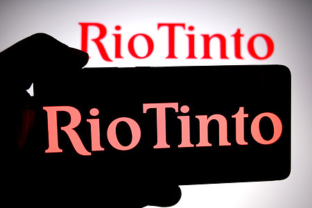 In this photo illustration, a Rio Tinto logo is seen displayed on a smartphone and in the background.