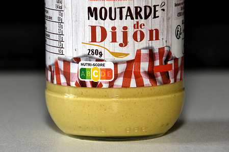 In this photo illustration, a NUTRI-SCORE “C” seen on a jar of Dijon mustard. A new version of NUTRI-SCORE, which is more stringent with regard to certain products, has been validated by the French government.