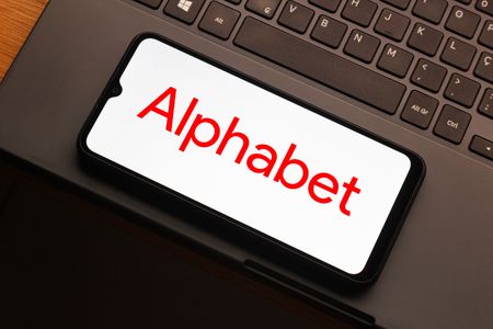 In this photo illustration, the Alphabet logo is seen displayed on a smartphone screen.