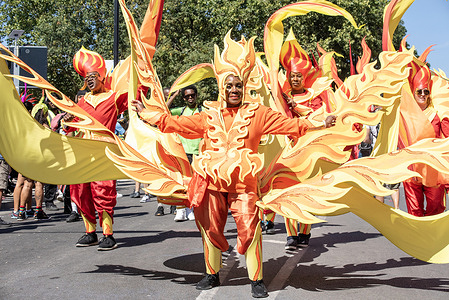 Masquerades dance in their beautiful dresses during the parade on the Notting Hill Carnival in London. The Notting Hill Carnival is one of the world's largest street festivals. It is an annual Caribbean Carnival that has taken place in London since 1966 on the streets of Notting Hill over the bank holiday weekend in August.