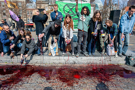 Activists are seen pouring fake blood during the protest.
Extinction Rebellion (XR) is an international movement that uses non-violent civil disobedience to achieve radical change in order to minimize the risk of human extinction and ecological collapse. From Monday 15 April, Extinction Rebellion is taking action on the streets of cities all over the world. In The Hague, the 'International Rebellion XR Netherlands' declared its own full-scale rebellion to demand decisive action from governments on climate change and ecological collapse. Also the Blood of our Children', a symbolic act where buckets of fake blood were poured on the street right next to the government offices to show the politicians that every second is more blood on their hands.