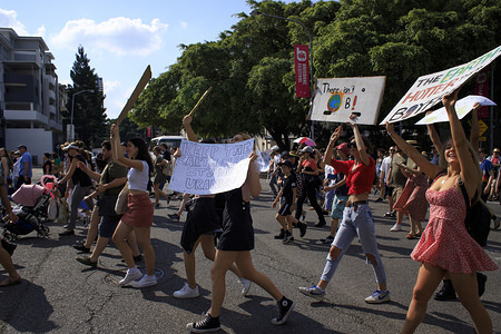 Protesters hold placards during the march.
Members of the public gathered in Brisbane to protest climate change inaction. Students and workers formed a massive strike and marched from Queen's Gardens to Musgrave Park.