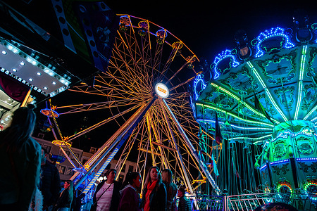 People are seen walking around the big Ferris wheel at the autumn fair. The fair is the oldest event in the city. It was created in 1273 after the dedication of the St. Stevens Church. It started with a mass and turned into an annual market at the end of the harvest. Over the centuries it became a week of relaxation for the population. This year hundreds of attractions have been placed around the city center. It's estimated that about 200,000 people visited the fair.