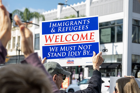 A protester holds a placard in Pasadena in response to an ICE-related incident in Minneapolis, calling for accountability and immigration reform.