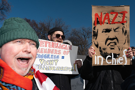 Protestors hold placards expressing their opinion during the demonstration. Thousands of protestors in D.C took part in the 50501 movement on Presidents Day. The movement originated in response to the Trump administration and its efforts to slash government spending.
