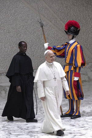 Pope Leo XIV arrives, followed by Father Edward Daniang Daleng, for the meeting with the employees of the Holy See, of the Governorate of the Vatican City State and of the Vicariate of Rome, to exchange Christmas greetings, in the Paul VI Hall at the Vatican.