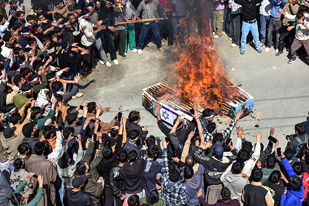 Kashmiri Shiite Muslim protesters shout slogans as they burn caskets draped with US and Israeli flag during a protest rally against the U.S. and Israel to mark the International Quds day (Jerusalem Day) in support of Palestine.