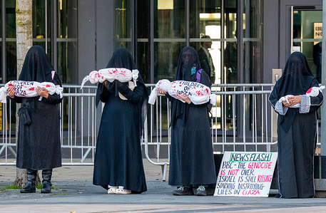 Protesters with mock shrouded baby bodies protest outside Quay House home to the BBC. Protesters supporting Palestine gathered at Media City to protest outside the BBC studios complaining about media bias in covering the Israel- Gaza conflict. The protesters marched around media city carrying placards complaining against BBC bias covering the war.