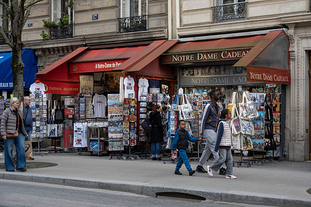 People walk by the gift shops near the Notre Dame in Paris. Paris, France's capital, is a major European city and a global center for art, fashion, gastronomy and culture. It is located on the both sides of the River Seine and around 50 million tourists visit it each year.