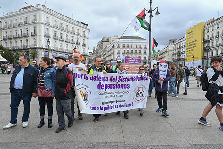 Protesters with banners march on the street during a demonstration in defense of the Public Pension System, demanding decent public pensions at Puerta del Sol.