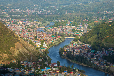 View of residential houses surrounded by mountains at Baramulla some 55km, north of Srinagar Kashmir. Baramulla is a border area in Jammu and Kashmir, resting on the banks of River Jhelum and surrounded by the Himalayas.