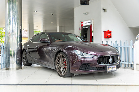 A close-up of a Maserati parked with the license plate number 666, a symbol of luck and prosperity in Chinese culture, in front of an ATM of a Chinese bank on Lat Phrao Road in Bangkok.