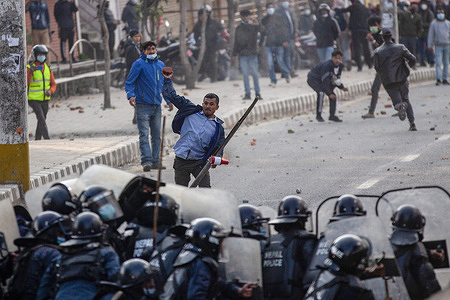 Protesters hurl bricks and stones at the riot police during a protest in Kathmandu.Different political parties youth wings clash with Nepal police outside Federal Parliament in protest against a US$ 500 million grant known as the Millennium Challenge Corporation (MCC) pact. The agreement, signed in 2017, is yet to be ratified by parliament which has until the end of February 2022 to do so. Protesters say the deal undermines Nepal's sovereignty, handing too much influence to the US.