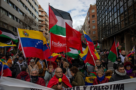Protesters rally amidst Venezuelan and Palestinian flags during the demonstration. The "anti-imperialist" march, which traveled through the streets of Madrid from the Ministry of Foreign Affairs to the United States Embassy, ​​sought to show solidarity with peoples oppressed by the US and colonialism, including Venezuela and Palestine.