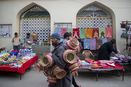 A Kashmiri street vendor carries traditional woven fire pots for sale on a cold winter day in Srinagar.
