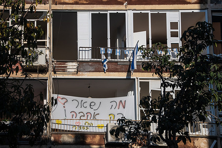 A banner seen hanging on a damaged building hit by an Iranian missile in Bat Yam, with the inscription: "What's left? Only love, everything is fine".