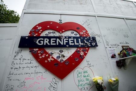 Grenfell's logo with massages at the foot of the tower.
On the first anniversary of the Grenfell Tower fire, the area around the tower has been filled with flowers, candles and messages to remember those who lost their lives.