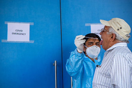 A health worker wearing a personal protective equipment suite (PPE) takes a swab sample from a man for a Reverse Transcription Polymerase Chain Reaction (RT-PCR) test.
The covid-19 testing Centre at Atlanta Mediworld Multispecialty Hospital, today India reported highest single day rise of covid-19 cases with 168912 positive cases.