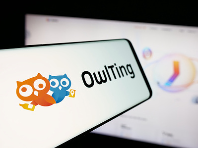 In this photo illustration, a smartphone with the logo of blockchain technology company OwlTing Group is seen on screen in front of website.