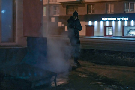 A lonely dark figure emerges from behind the corner of a building on a deserted street in winter. Lipetsk is a provincial town 100 km from the main highway connecting 15-million Moscow and 1-million Voronezh. Voronezh is 150 km away and Moscow is 400 km away.
