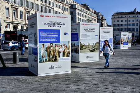 A woman seen walking past the memorial exhibition of the commemoration of the 80th anniversary of the liberation of Marseille, on the Quai de la Fraternité in Marseille. On the occasion of the commemoration of the 80th anniversary of the liberation of Marseille, a memorial exhibition in the form of cubes on the Quai de la Fraternité (Vieux-Port) recounts episodes of the retaking of the city and pays tribute to the fighters of 1944.