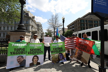 Protesters hold banners and wave flags during a demonstration against the Azerbaijani government. Azerbaijani political exiles stage a protest against the governement near the White House during a meeting between the presidents of Azerbaijan, Armenia, and the United States.