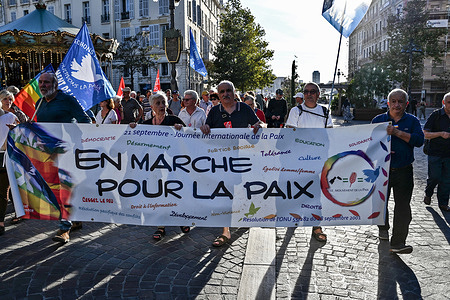 Protesters holding a banner and flags march through the streets of Marseille during the demonstration. To mark the International Day of Peace, around a hundred people gathered and marched through the streets of Marseille.