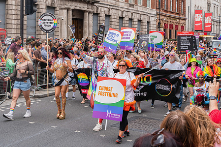 LGBT participants march with placards and banners during the Pride event in London. Pride activity in London Trafalgar Square stage acts, and hundreds of attendees participate.