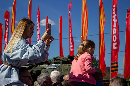 A woman takes photos at a newly opened exhibition of trophy military equipment in Moscow. The posters behind her read “Victory.” An exhibition of trophy military equipment captured by Russian servicemen during the Russian-Ukraine war, known as the special military operation in Russia, opened in the Victory Park in Moscow on May 1, 2024. Damaged, destroyed, and captured military equipment of NATO countries and Ukraine are exhibited to the Russian public. The Russian-Ukraine war began on February 24, 2024. Since then the NATO countries have been supplying the Ukraine army with weapons.