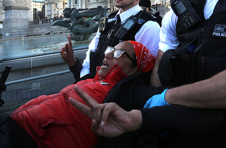 A protester gives a two-fingered peace salute as she is carried off after being arrested during the protest. Following the ruling by a panel of judges at the judicial review reporting earlier this year that found the government’s proscription of pro-Palestinian direct action group Palestine Action as unlawful over 500 supporters of Defend Our Juries sat in Trafalgar Square holding signs saying, "I oppose genocide. I support Palestine Action”. The government are due to appeal the ruling and until that has reached a conclusion support for Palestine Action is still technically against the law. Despite the police originally announcing they were not going to arrest activists anymore for holding the controversial sign they have changed their minds and arrested everyone showing signs supporting the banned group