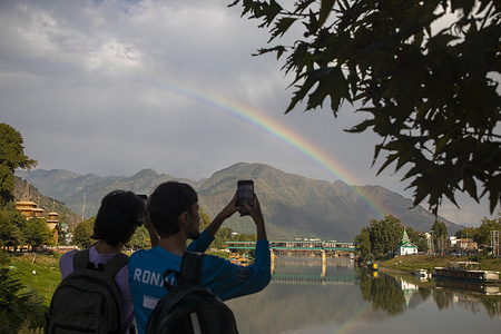 Kashmiri boys take photos as rainbow appears over the Jhelum River after a brief spell of rainfall in Srinagar, the summer capital of Jammu and Kashmir.
