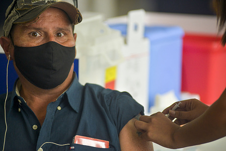 A Salvadoran gets a dose of the Chinese SINOVAC COVID-19 vaccine at a vaccination facility.
The Salvadoran President announced the beginning of the mass vaccination operations at a mass vaccination center in the country's capital in a bid to vaccinate about 30,000 Salvadorans daily.