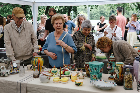 Senior customers seen choosing vintage tableware at the local flea market in central Moscow. People chose vintage tableware, retro photos and pictures at the local flea market in Frunzenskaya embankment.