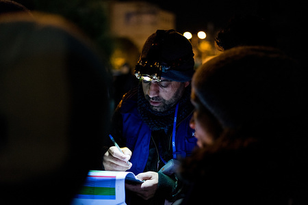 A member of the International Organisation for Migration (IOM) registers refugees boarding buses.
About 650 refugees and migrants arrived by ship to the port of Piraeus late at night with a purpose of moving them to the Ritsona refugee camp.