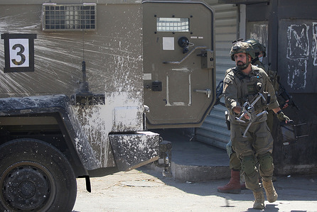 An Israeli soldier carries a drone at the entrance to the market during a raid on Balata refugee camp east of Nablus in the West Bank. Israeli forces raided the central market during a security operation. Palestinian sources said that the army arrested seven Palestinians from various neighborhoods in Nablus and its surrounding refugee camps.