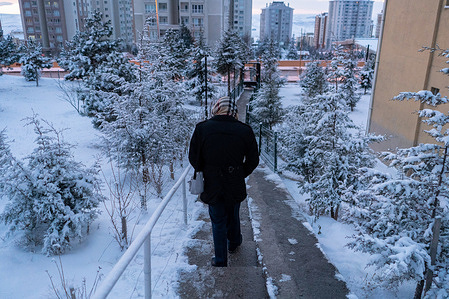 A man goes to work in the morning in the snowy weather.