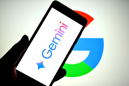 In this photo illustration, a Gemini AI logo is seen displayed on a smartphone with a Google logo in the background.
