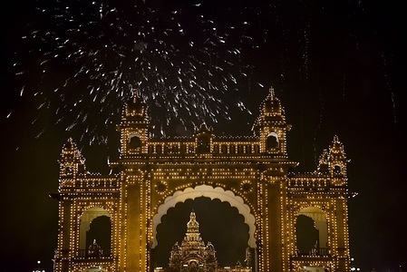 Thousands of spectators seen gathering to watch a spectacular fireworks display over the illuminated Mysore Palace to celebrate the arrival of the New Year on January 1st, 2026. The historic palace, a major tourist landmark, is traditionally lit with nearly 100,000 light bulbs during major festive occasions.